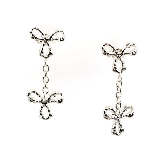 Silver bow-shaped earrings on a white background