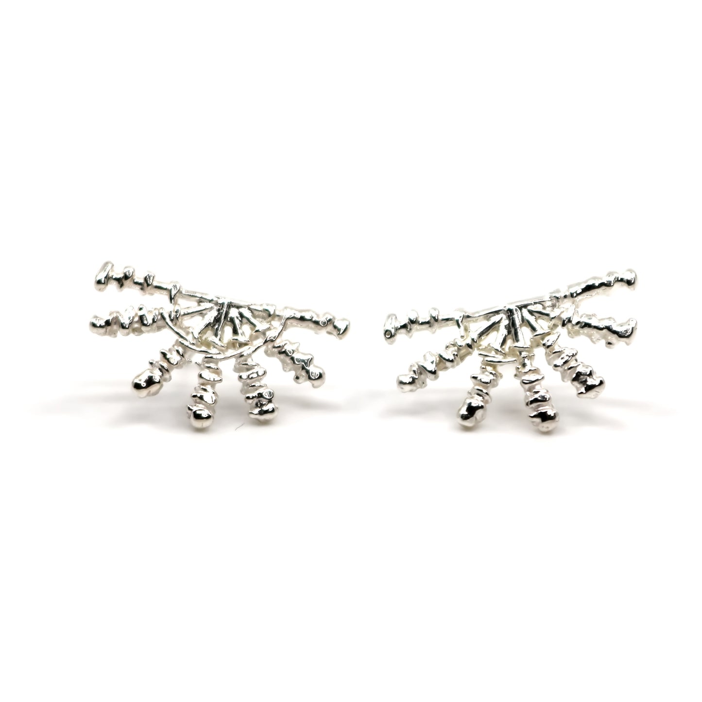 Pair of silver sunray shaped earrings on a white background