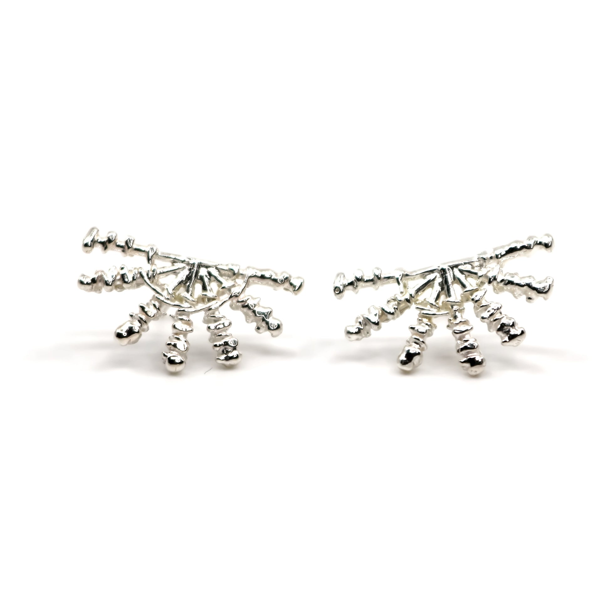 Pair of silver sunray shaped earrings on a white background