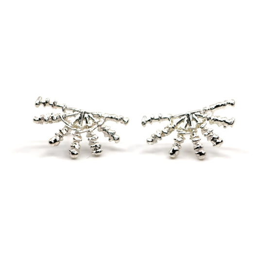 Pair of silver sunray shaped earrings on a white background
