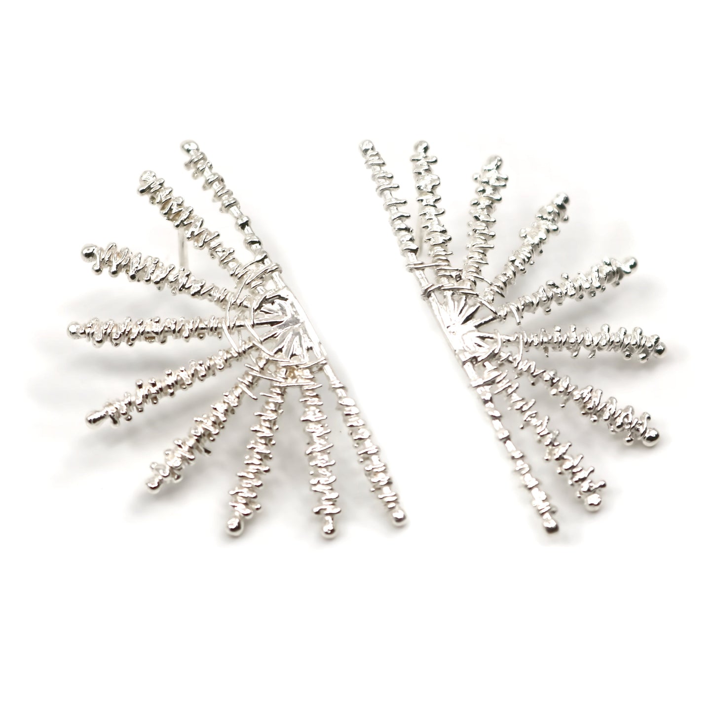 Pair of silver sunray shaped earrings on white background